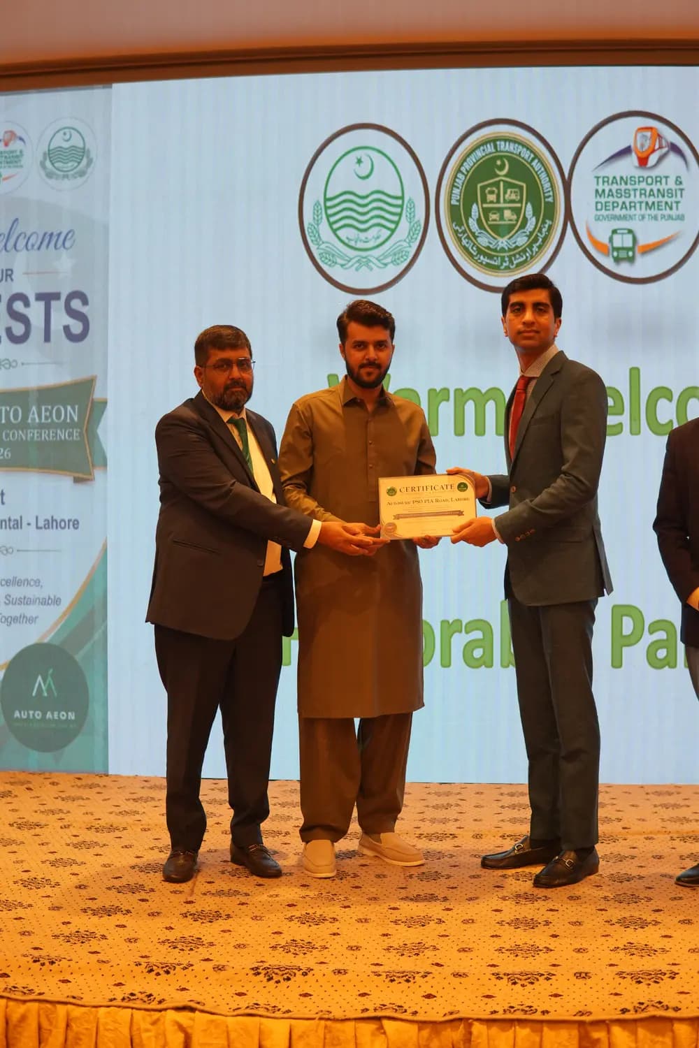 An Auto Aeon franchise partner receiving their certificate on stage