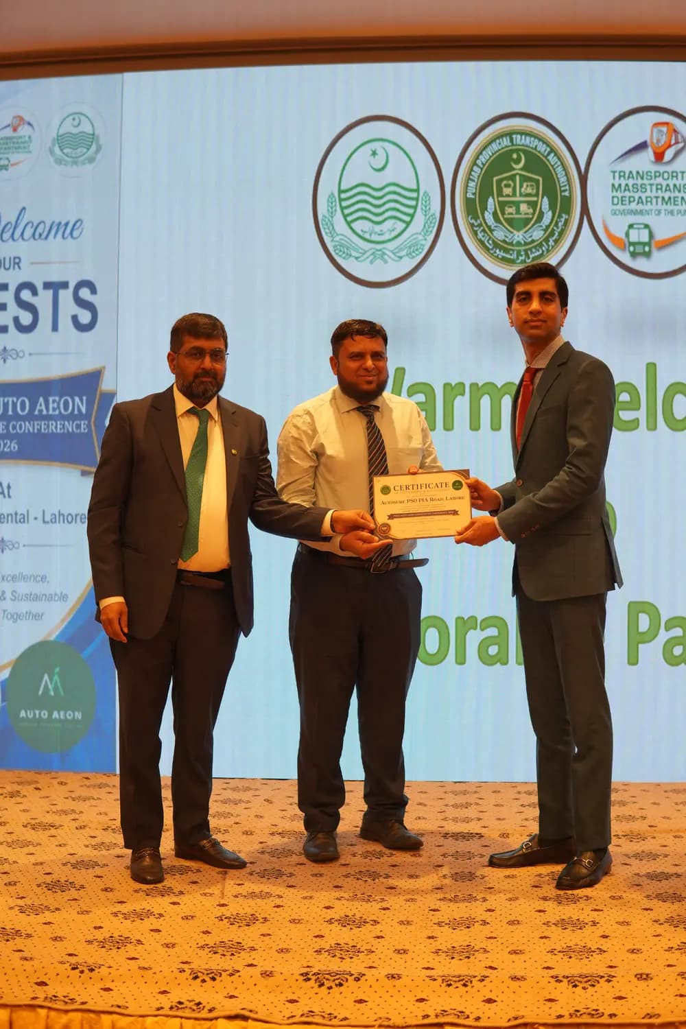 An Auto Aeon franchise partner receiving their certificate on stage